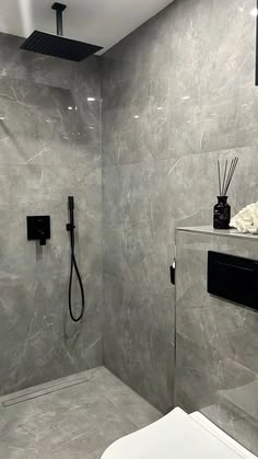 Minimalist walk-in shower with large gray porcelain wall tiles and matte black fixtures